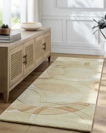 Entryway with a Desert Tan Theta Modern Wool Rug, light wood floors, and a rattan cabinet. Roomscene-Runner