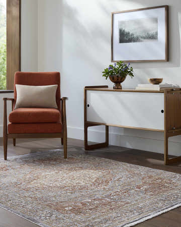 Living room scene with an orange chair and the traditional Tulio Area Rug. Roomscene-Rectangle