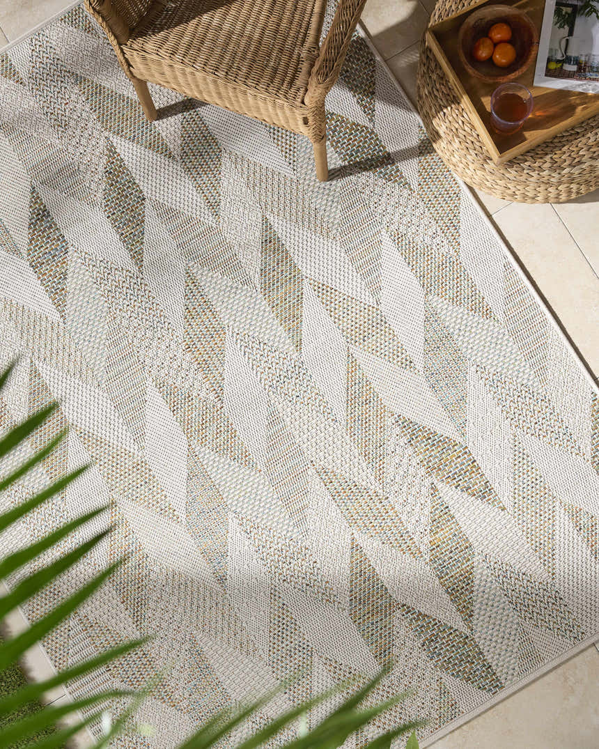 Close-up of Andrea Ivory Area Rug featuring a geometric diamond pattern in ivory, sage, sandstone, and sky blue hues. Roomscene-Rectangle