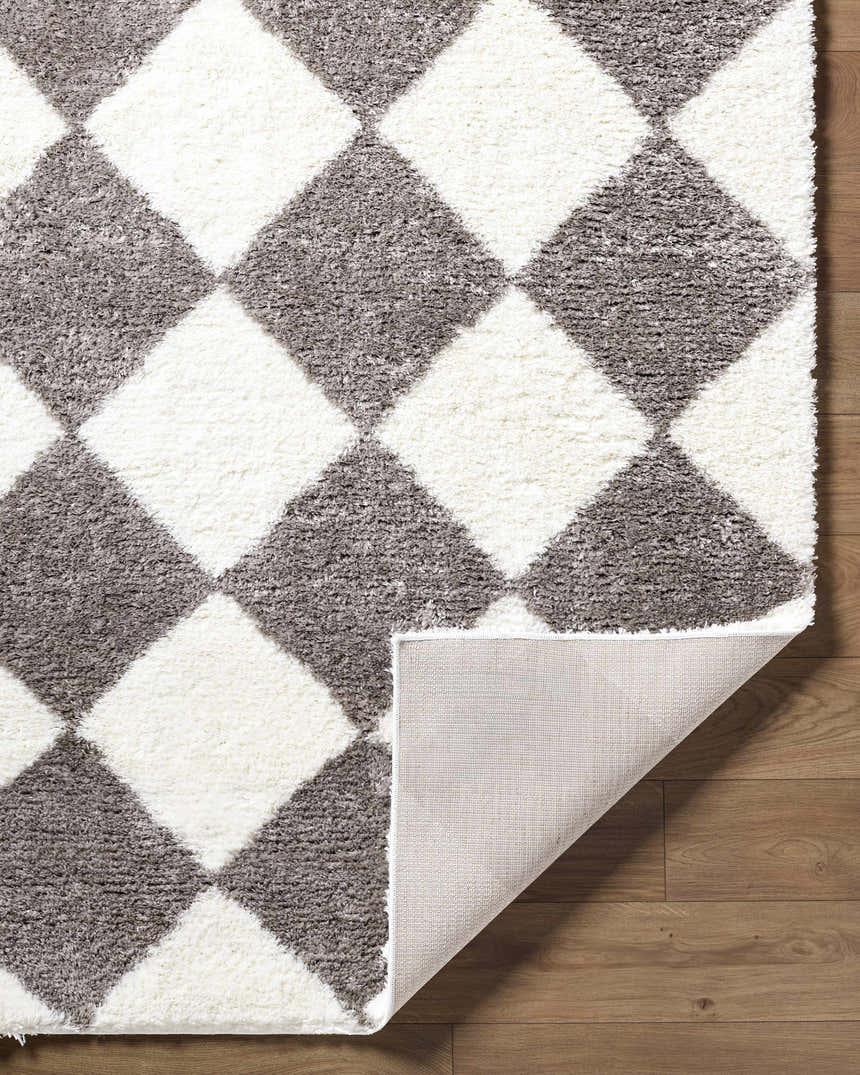 Close-up of the Achaia Dark Gray Area Rug featuring a gray and white diamond pattern and shag texture. Fold