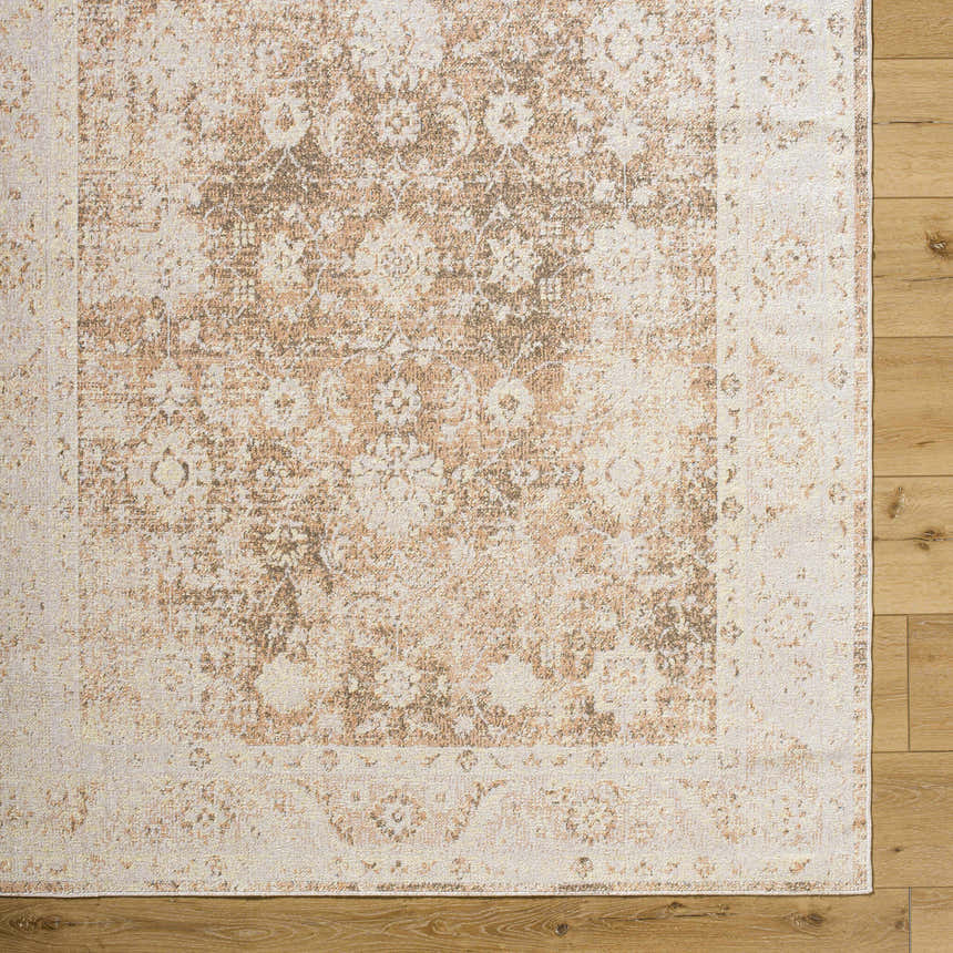 Close-up of the Aniyah Washable Area Rug. Traditional floral pattern in ash, pearl, prairie dust, and tan colors. Corner