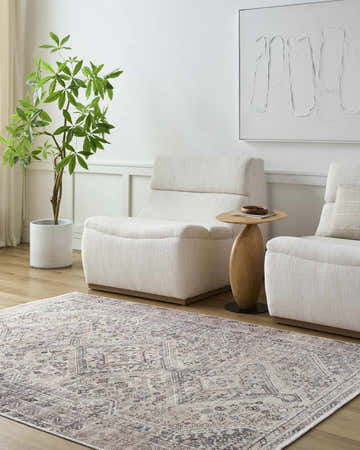Living room scene with beige Trula Washable Area Rug, light gray chairs, wood floors, and modern art. Calm, neutral tones. Roomscene-Rectangle