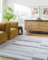 Living room scene with a light silver Tayla Shag Area Rug, mustard chairs, and a wood cabinet. Roomscene-Rectangle