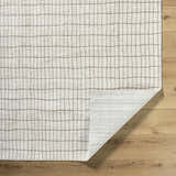 Close-up of the ivory Cascade White Area Rug showing its taupe grid pattern and machine-woven construction. Fold
