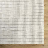 Close-up of the Cascade White Area Rug showing its ivory color and taupe grid pattern on a wood floor. Swatch