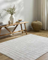 Entryway with a Cascade White Area Rug, wooden bench, vases, books, and woven basket. Farmhouse style. Roomscene-Rectangle