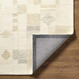 Close-up of the hand-tufted Tovah Area Rug. Ash and light silver wool rug with a contemporary geometric pattern. Fold