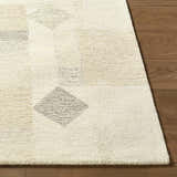 Close-up of the hand-tufted Tovah Area Rug. Ash and light silver wool with a geometric diamond pattern. Contemporary style. Front