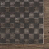 Close-up of the Truls 3D Checkered Washable Rug in Black and Gray. Features a textured, checkered pattern on a wood floor. Swatch