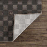 Close-up of the Truls 3D Checkered Washable Rug in black and gray, showcasing its textured checkered design and non-slip backing. Fold