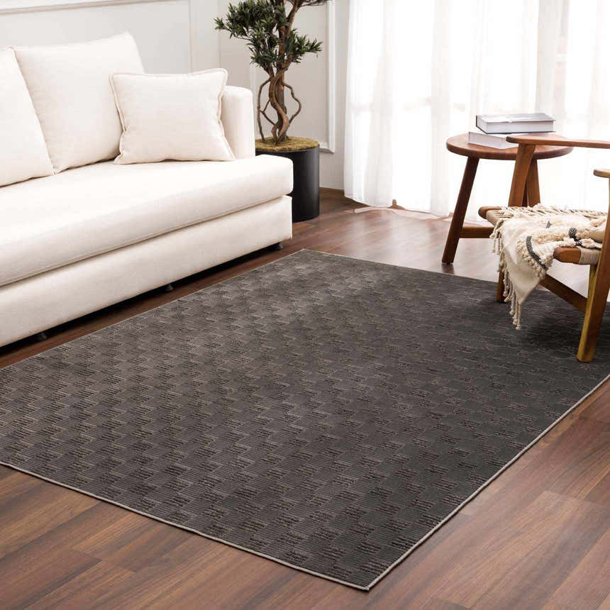 Living room scene with a Truls 3D Checkered Washable Rug in black, white sofa, wood floors, and natural light. Roomscene-Rectangle