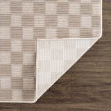 Close-up of Truls 3D Checkered Washable Rug in Biscotti. Beige and cream checkered pattern with a textured, machine-woven construction. Fold