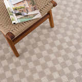 Close-up of the Truls 3D Checkered Washable Rug in Biscotti, showing beige and cream checkered pattern and textured weave. Styleshot