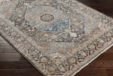 Close-up of the traditional Baychester Brown Area Rug, featuring dark brown, denim, and sage tones. Corner