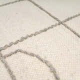 Close-up of the Tieve Black & White Grid Wool Rug showing the cream wool and gray hand woven grid pattern. Texture