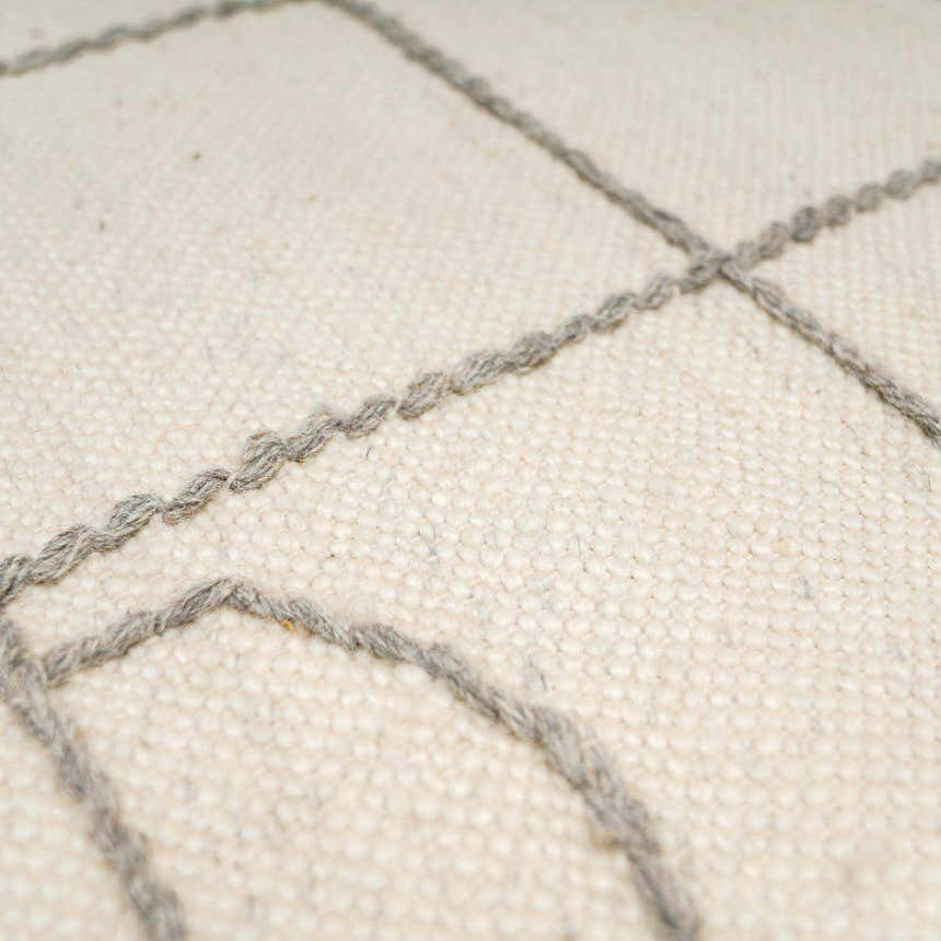 Close-up of the Tieve Black & White Grid Wool Rug showing the cream wool and gray hand woven grid pattern. Texture