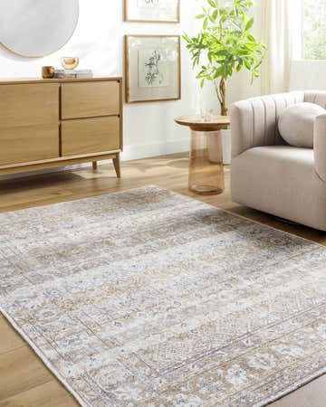 Living room scene with a beige Tywin Vintage Flat Pile Washable Rug, light wood furniture, cream armchair, and neutral decor. Roomscene-Rectangle