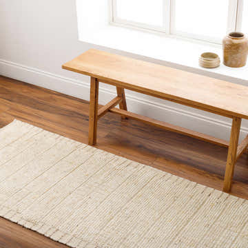 Entryway scene with a beige Turi Area Rug, wooden bench, and brown wood floors. Farmhouse style. Roomscene-Runner