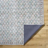 Close-up of the Telma Medium Green Washable Area Rug showing its traditional, farmhouse-style pattern and colors. Fold
