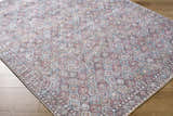 Close-up of the Telma Red Washable Area Rug showing its traditional geometric pattern and colors of red, aqua, and cream. Corner