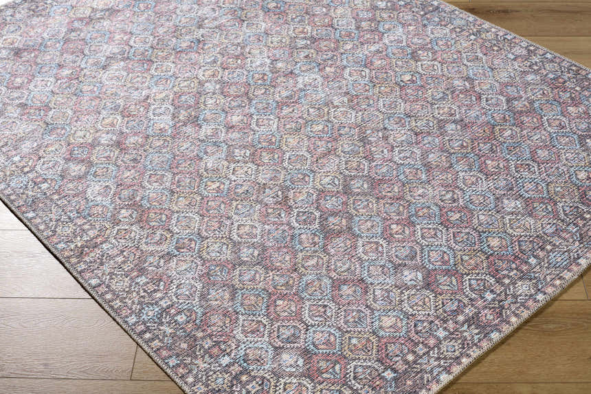 Close-up of the Telma Red Washable Area Rug showing its traditional geometric pattern and colors of red, aqua, and cream. Corner