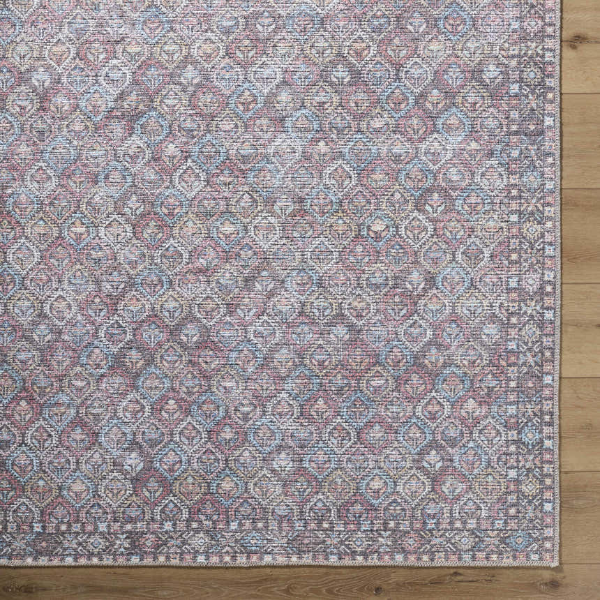 Close-up of the Telma Red Washable Area Rug, a traditional design in aqua, cream, red, and pink on a wood floor. Corner