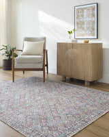 Living room scene with gray chair, wood cabinet, and Telma Red Washable Area Rug with red, aqua, and cream geometric pattern. Roomscene-Rectangle