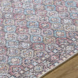 Close-up of the Telma Red Washable Area Rug. Features a traditional geometric pattern in red, aqua, cream, and mustard tones. Texture