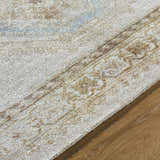 Close-up of the hand-tufted Tarun Area Rug showing beige, ivory, sandstone, and sky blue colors, plus traditional pattern. Texture