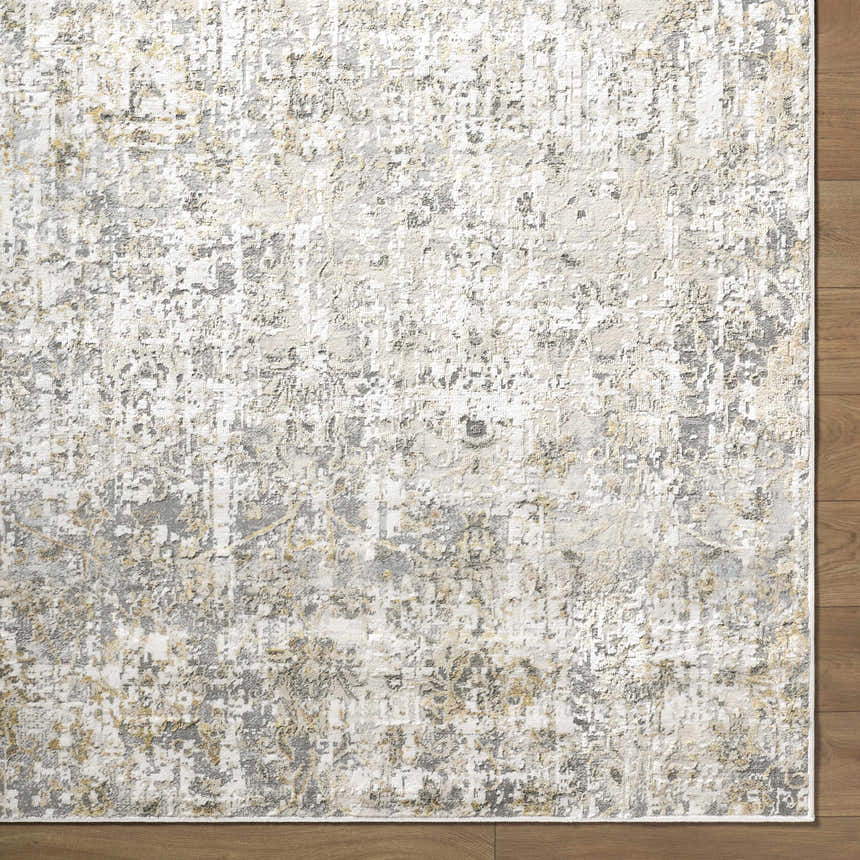 Close-up of the Tiago Area Rug, a contemporary rug in beige, charcoal, cream, gray, and ivory on a wood floor. Corner