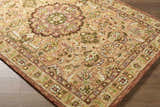 Close-up of the hand-tufted Annick Area Rug. Farmhouse style with traditional floral pattern in beige, green, and brown wool. Corner