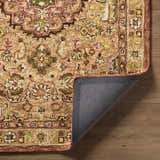 Close-up of the hand-tufted Annick Area Rug. Farmhouse style rug with a traditional floral pattern in peach, green, and brown tones. Fold