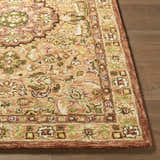 Close-up of the hand-tufted Annick Area Rug. Farmhouse style rug features a traditional floral pattern in peach, green, and cream. Front