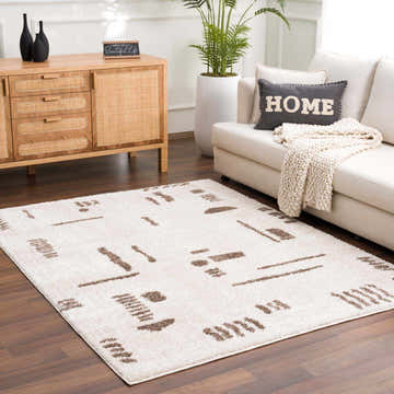 Living room scene with Azriel Brown Washable Area Rug. Beige sofa, wood cabinet, and potted plant create a cozy, modern space. Roomscene-Rectangle