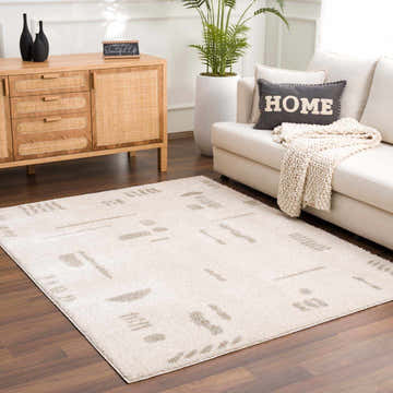 Living room scene with Azriel Gray Washable Area Rug, sofa, wood cabinet, and potted plant for a contemporary, cozy feel. Roomscene-Rectangle