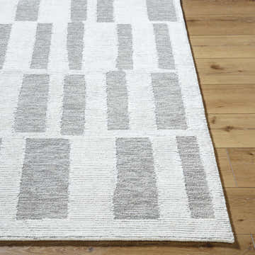 Close up of the Teige Ivory Area Rug showing the stone gray geometric pattern and wool texture. Front