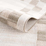 Close-up of the Azrika Beige Checkered Washable Rug, showing its soft texture and geometric pattern in beige and brown tones. Fold