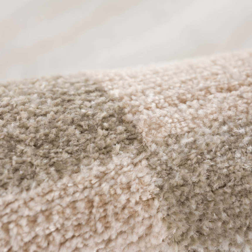Close-up of the Azrika Beige Checkered Washable Rug showing the soft, textured polyester and beige and brown checkered pattern. Fold