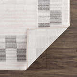 Close-up of the Azrika Gray Checkered Washable Rug showing the geometric pattern and the rug's backing. Fold