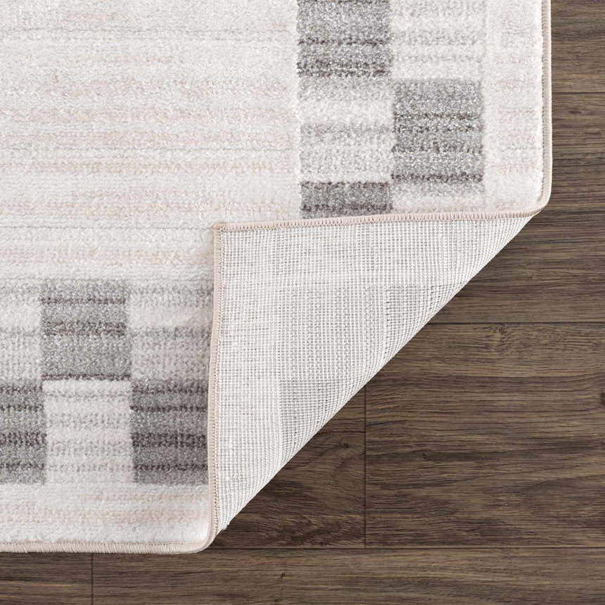 Close-up of the Azrika Gray Checkered Washable Rug showing the geometric pattern and the rug's backing. Fold