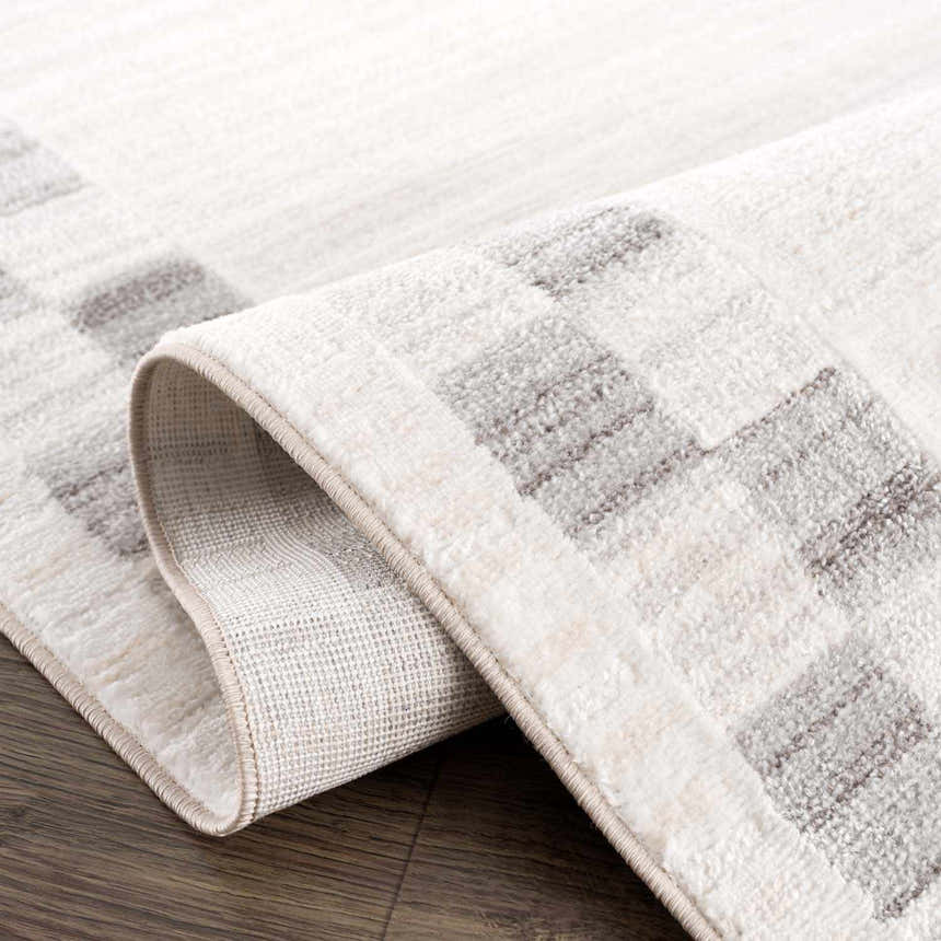 Close-up of the Azrika Gray Checkered Washable Rug showing the geometric pattern and soft texture. Fold