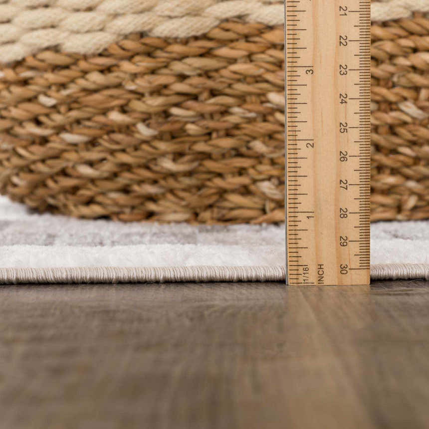 Close-up of Azrika Gray Checkered Washable Rug showing the pile height with a ruler and a woven basket in the background. Pile