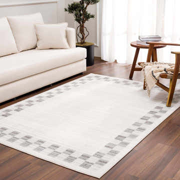 Living room scene with a beige sofa and the Azrika Gray Checkered Washable Rug on hardwood floors. Roomscene-Rectangle