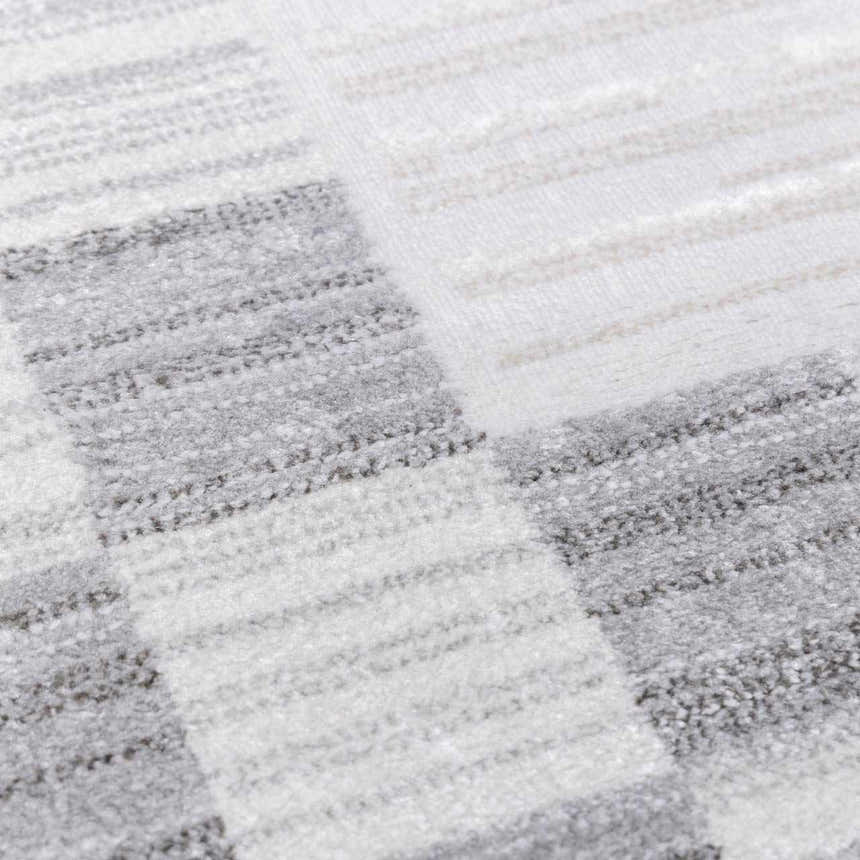 Close-up of the Azrika Gray Checkered Washable Rug, featuring a geometric beige and gray pattern. Texture