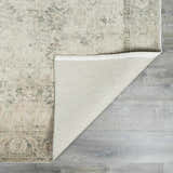Close-up of Fetscher II Vintage Medallion Area Rug showing beige, light brown, olive, and peach colors and backing. Fold