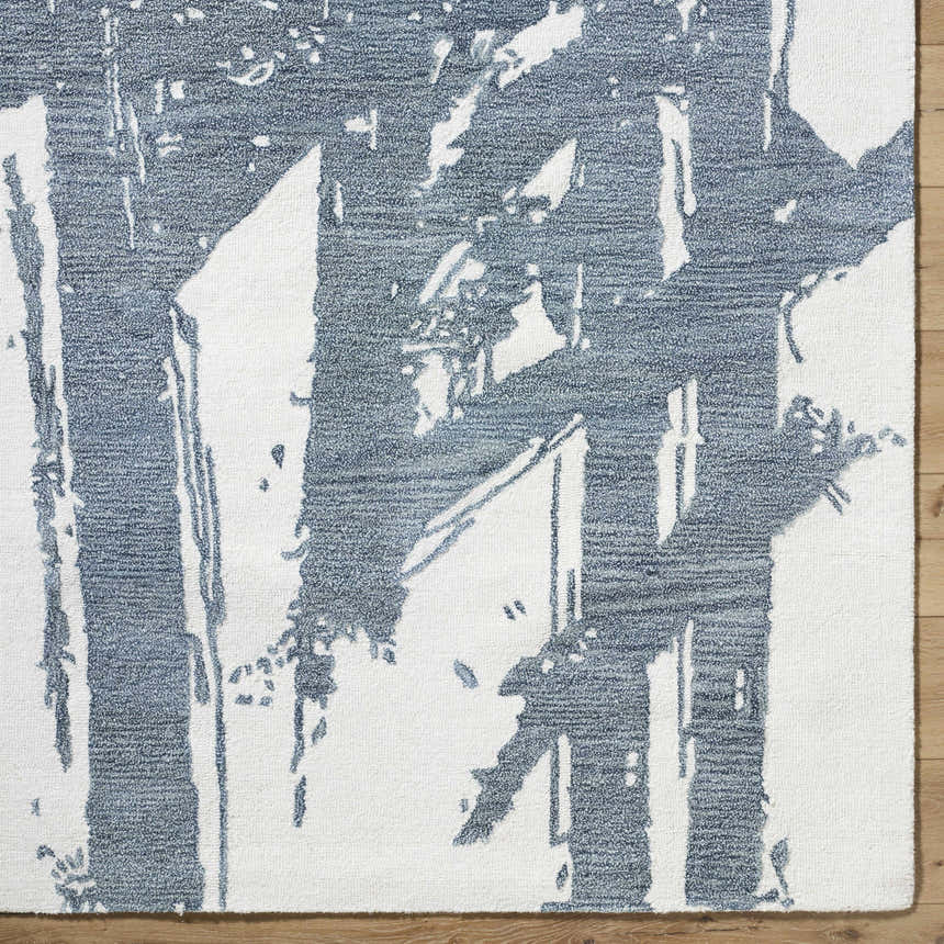 Close up of the hand-tufted Viven Slate Blue Area Rug. Abstract blue and white pattern on a wool rug. Corner