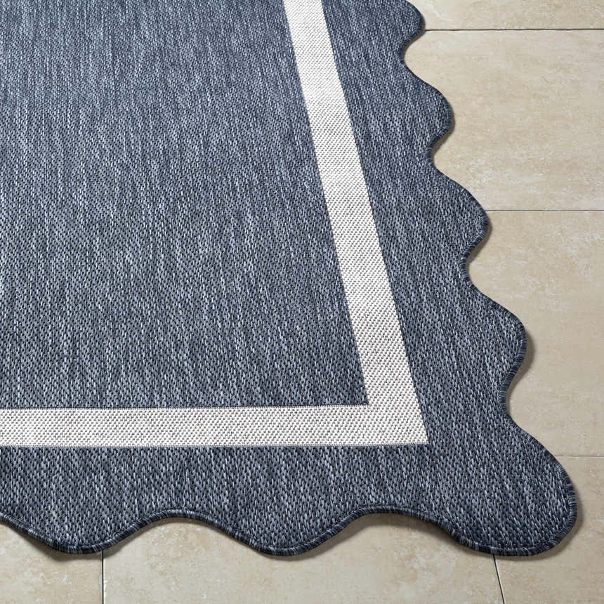 Close-up of the Varro Navy Area Rug showing texture, cream border, and unique scalloped edge. Front