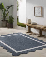 Entryway with a Varro Navy Area Rug, wooden bench, plants, and neutral decor. Farmhouse style. Roomscene-Rectangle