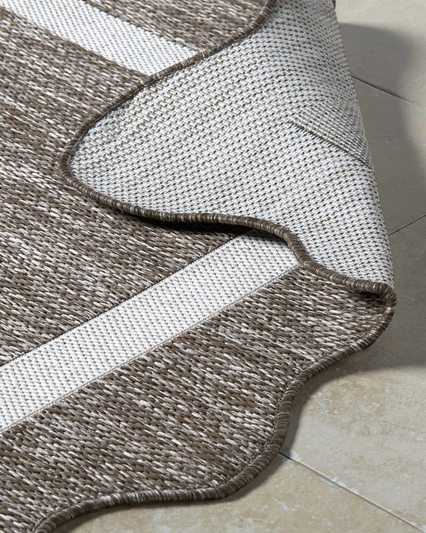 Close-up of Varro Dark Brown Area Rug showing cream and dark brown woven texture and bound edge. Fold