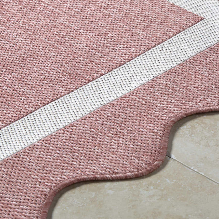 Close-up of the Varro Dark Pink Area Rug showing its woven texture, cream stripe, and scalloped edge. Texture